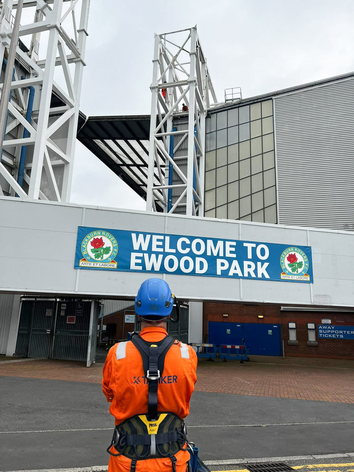 Taziker operative standing in front of the Ewood Park entrance.